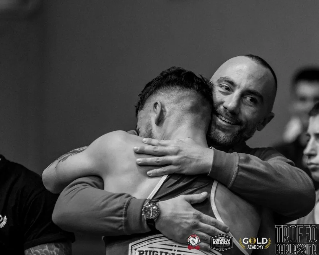 Bruno Elli, co-fondatore della Pugilistica Brianza, abbraccia un pugile con il trofeo a Barlassina