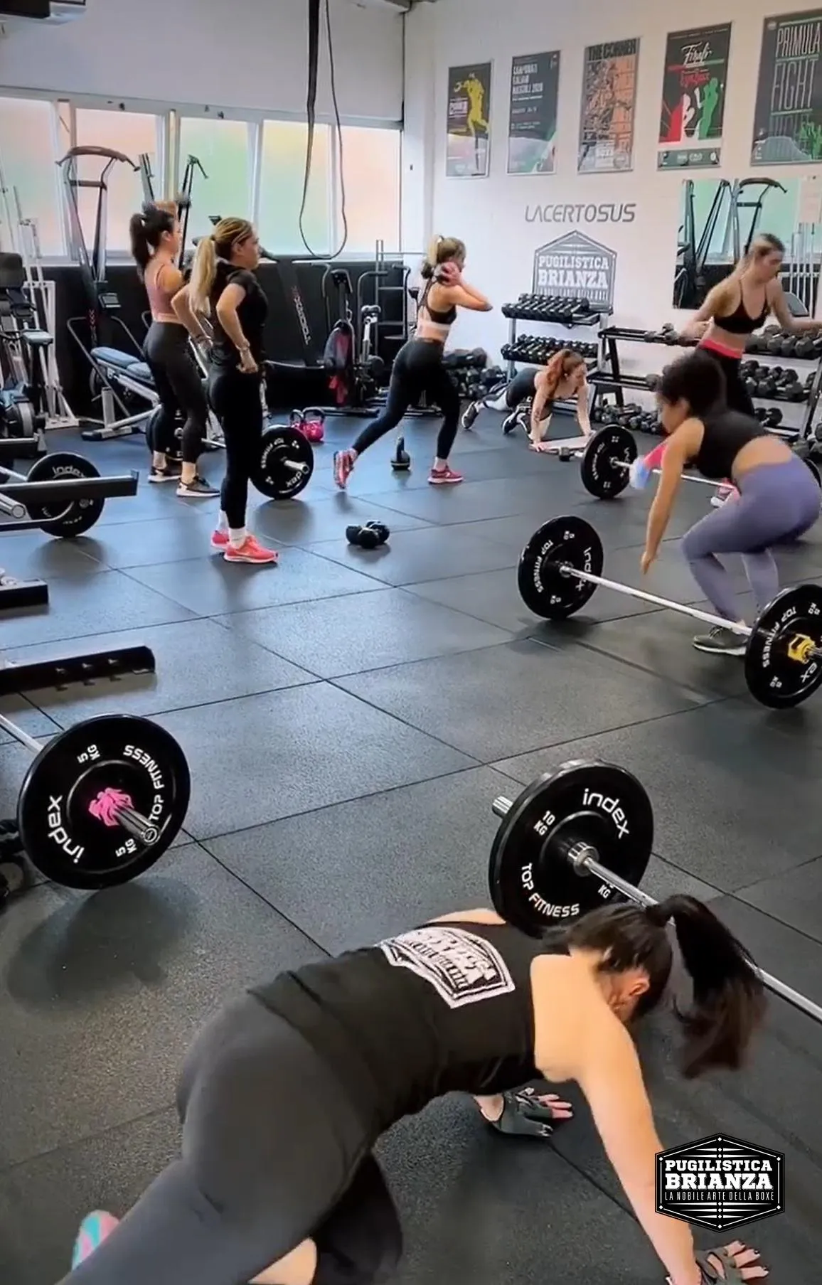 Circuito di gruppo PB Hiit: allieve su stazioni diverse con bilancieri e corpo libero